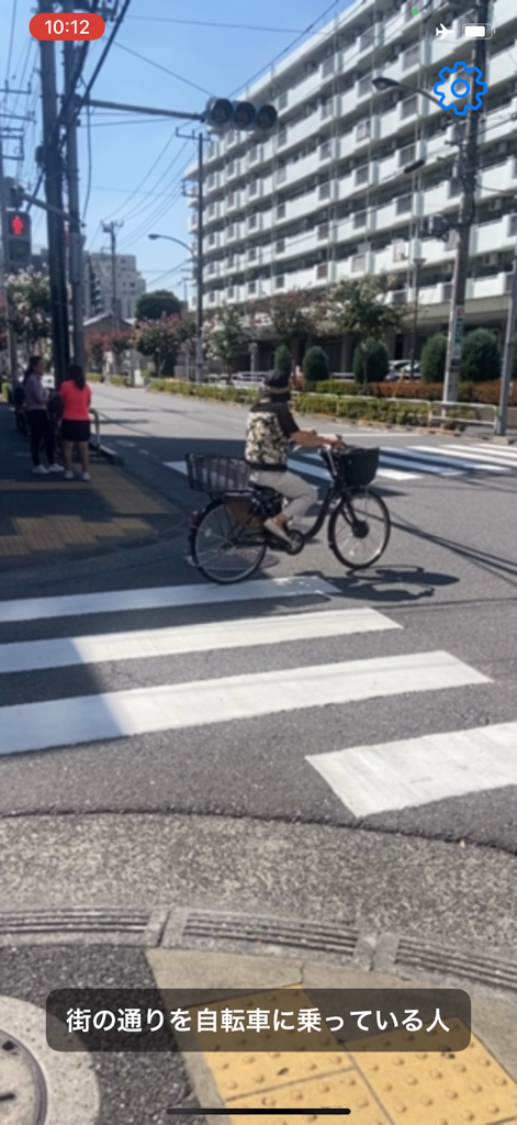 Talking Cam - Talking Cam app interface showing real-time AI recognition of a person riding a bicycle on a city street