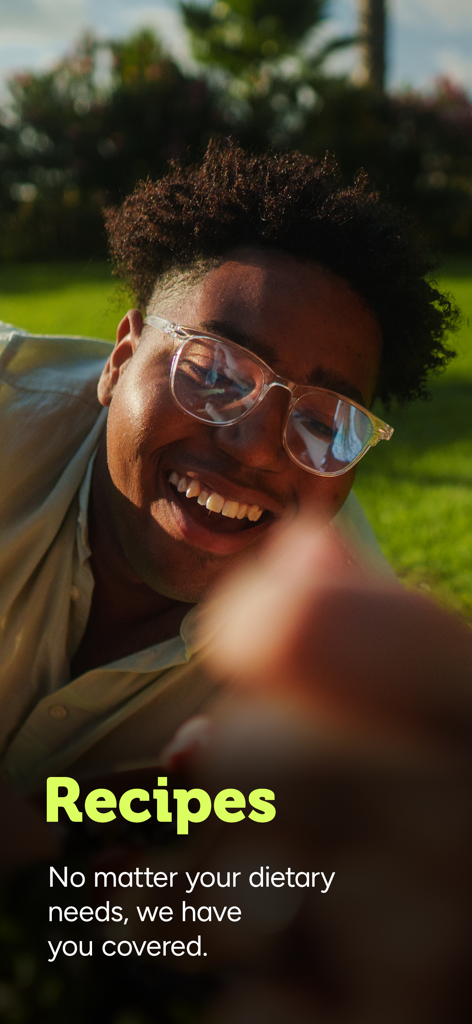 Lächelnde Person in einem Garten, die gesunde Rezepte in der Holland and Barrett App bewirbt.