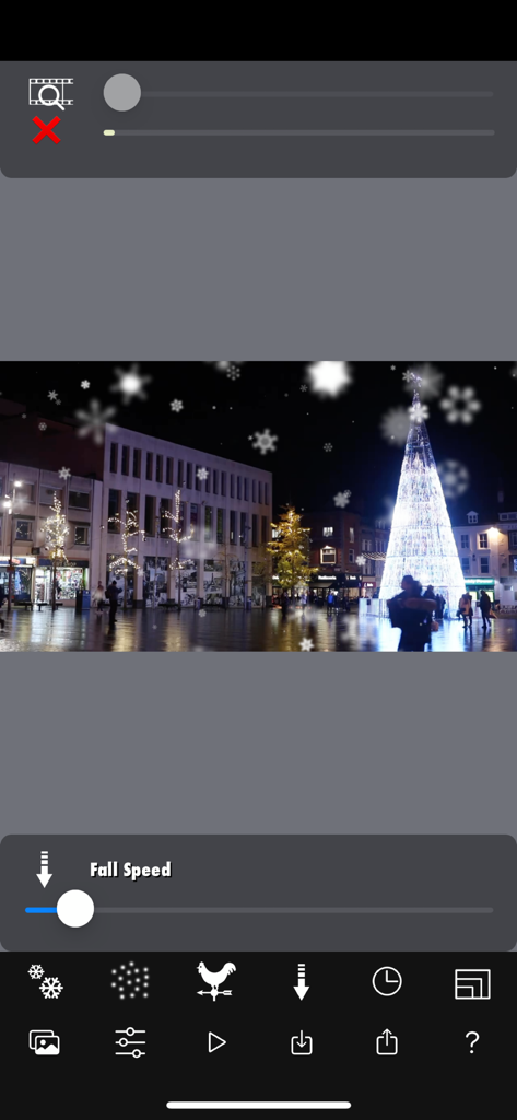 Snow Effect Video - クリスマスの木立のシーンと落下速度調整スライダーを示すスノーエフェクトビデオアプリのインターフェース