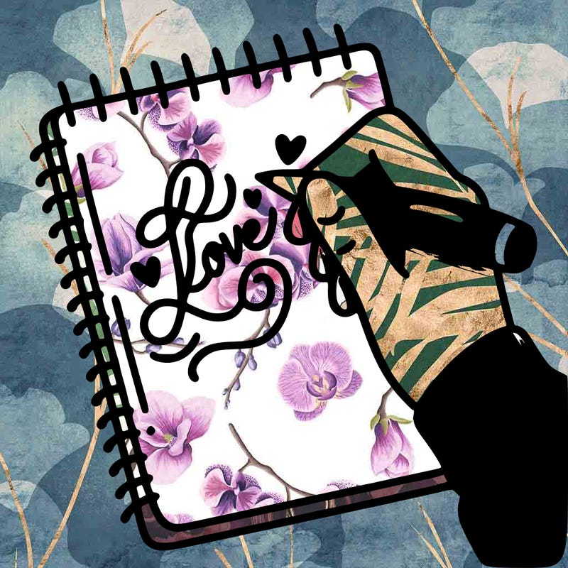 a hand writing “love” in calligraphy on a notebook