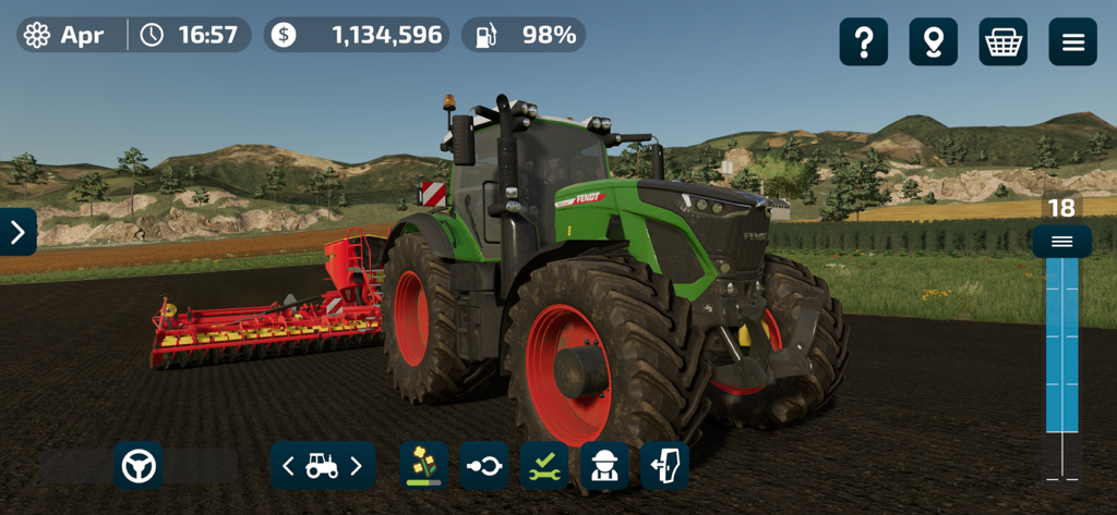 Farming Simulator 23 Mobile - A green Fendt tractor with a red attachment cultivating a field in Farming Simulator 23 Mobile