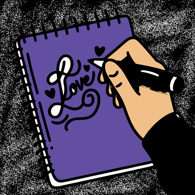 a hand writing “love” in calligraphy on a notebook