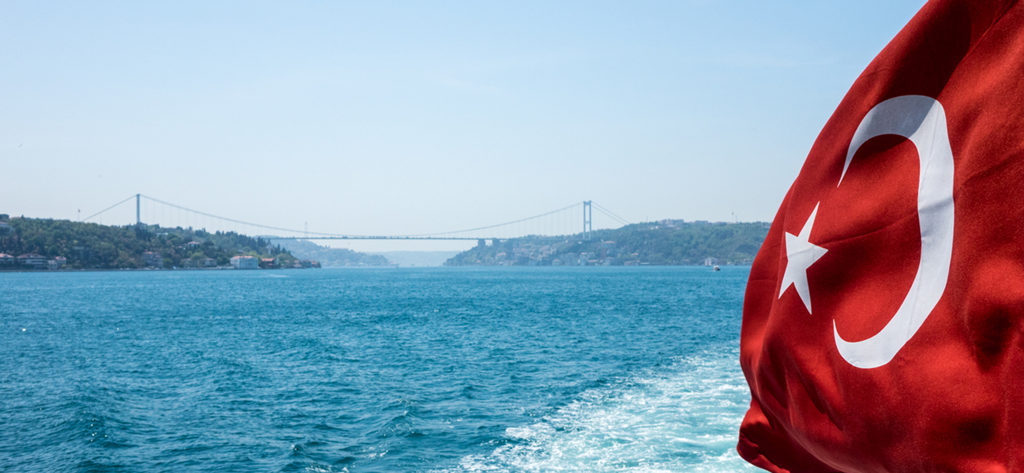 Turkish flag waving with the Bosphorus Bridge and Istanbul skyline in the background