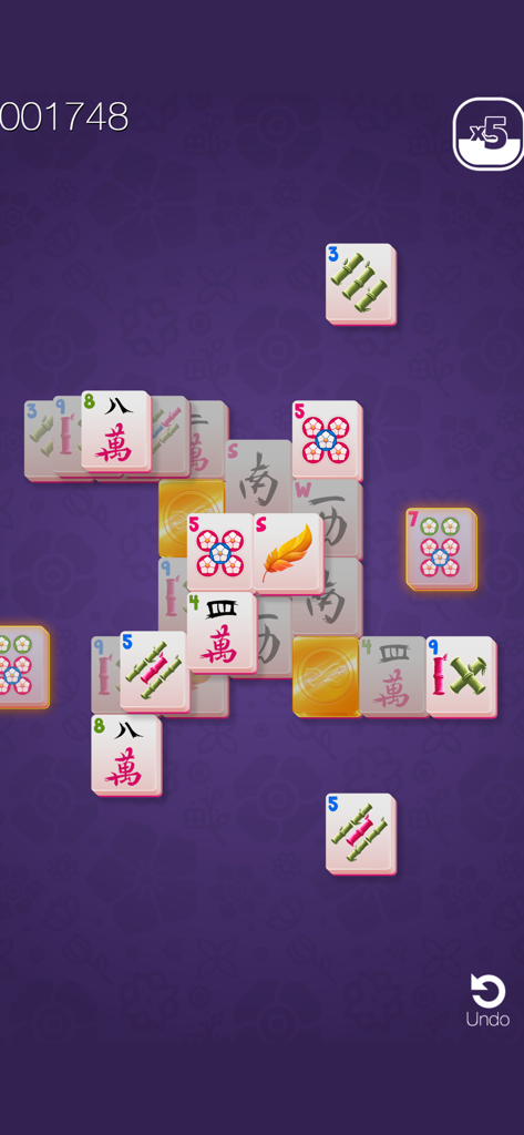 Una rilassante schermata di gioco di Mahjong Solitaire con tessere tradizionali su sfondo floreale viola.