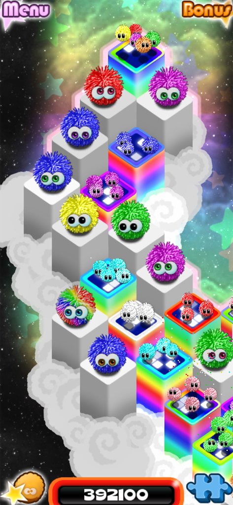 Chuzzle 2 - Colorful fuzzy Chuzzle characters sitting on a tower of rainbow blocks in a space-themed background