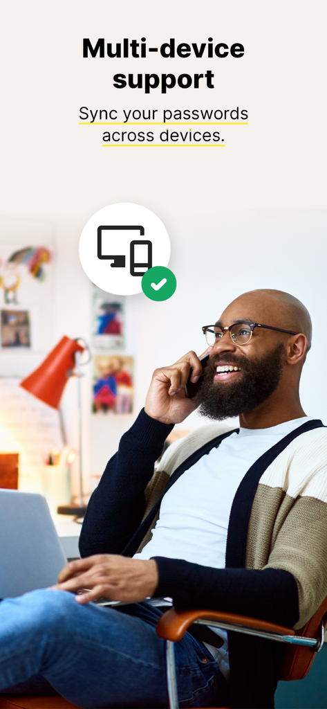 Norton Password Manager - Uomo che usa telefono e laptop che rappresentano la sincronizzazione multi-dispositivo di Norton Password Manager.