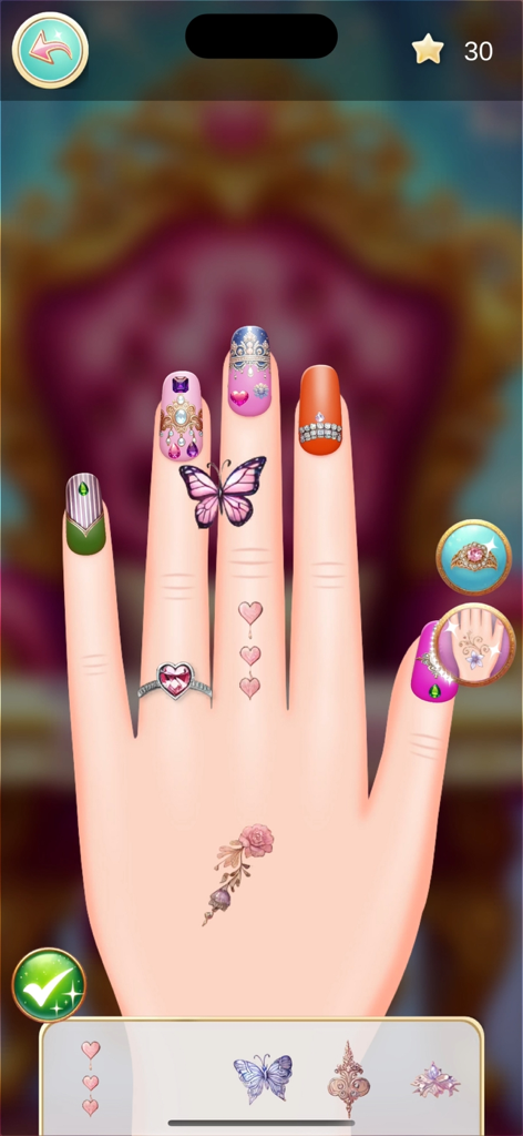 Princess- Make Over - Una mano con uñas decoradas y coloridas, un anillo de corazón y pegatinas de mariposa en la aplicación Princess Make Over.