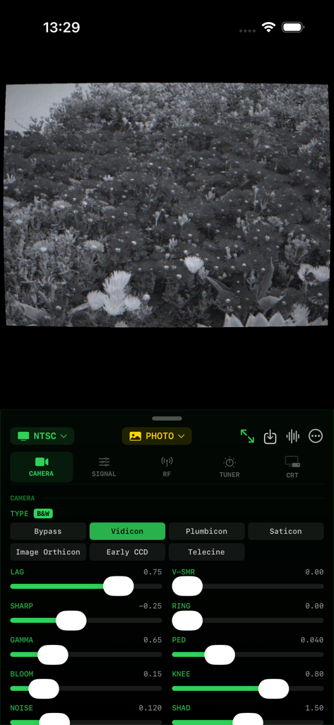 AnalogTV - AnalogTV app interface showing a black and white CRT effect on a field of flowers with technical camera settings and adjustment sliders for Vidicon tube simulation.