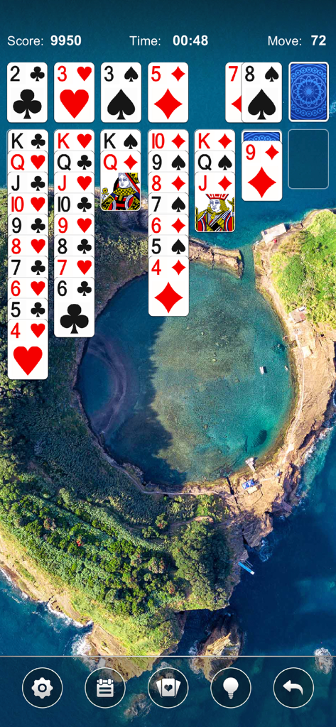 Solitaire Card Game by Mint - Un'interfaccia di gioco di solitario classico ambientata contro uno sfondo di un'isola tropicale panoramica