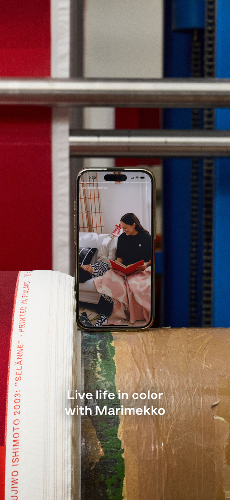 Marimekko | Fashion & Design - iPhone displaying the Marimekko app with the text Live life in color with Marimekko over rolls of printed fabric