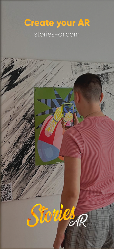 Stories AR - A user using the Stories AR app on a smartphone to animate a colorful painting on a wall