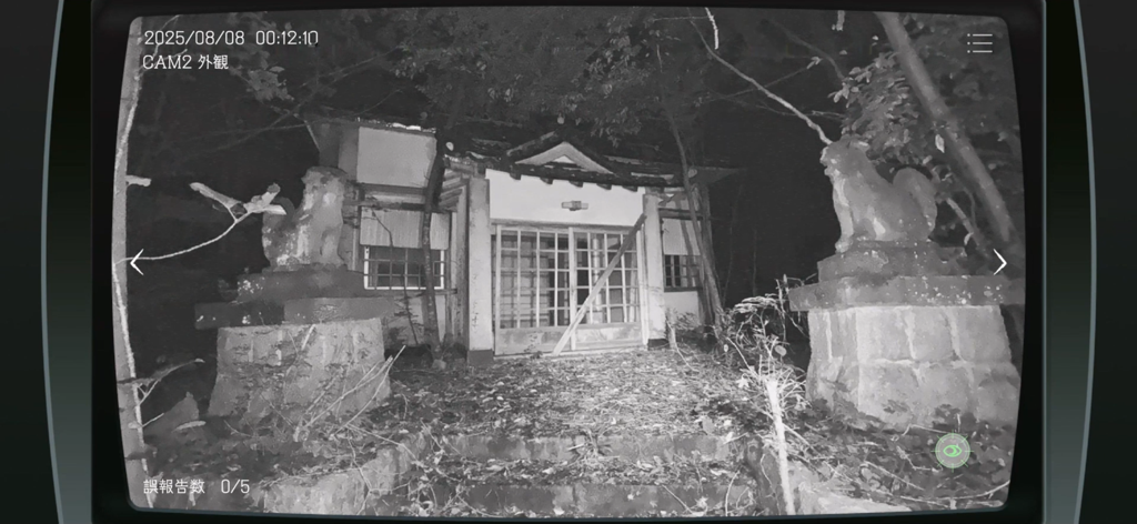 Japan Stigmatized Property - 石像のある古い日本の建物の外観を映した、夜間の白黒監視カメラ映像
