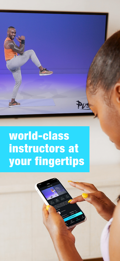 Eine Frau benutzt die NEOU-App auf ihrem Handy, während sie einem Fitness-Trainer auf einem großen Fernsehbildschirm zusieht.