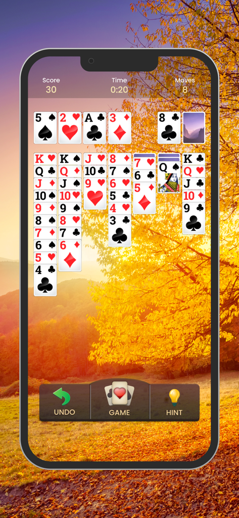 Solitaire gameplay on a phone with an autumn tree background.