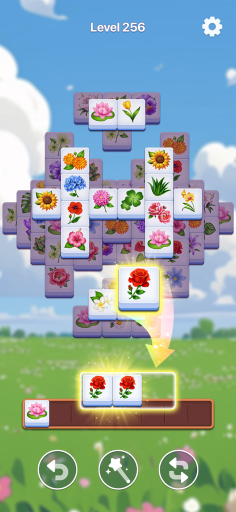 Bloom Tile gameplay showing flower tiles and level progress on a garden background
