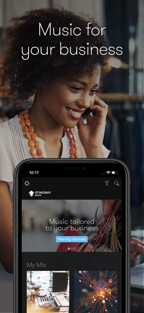 Stingray Music for Business app interface displayed on a smartphone with a boutique owner in the background.