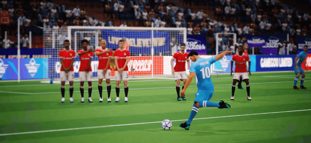 Ein Fußballspieler in blauem Trikot schießt einen Freistoß gegen eine Mauer aus roten Hemden in einer 3D-Stadionsimulation