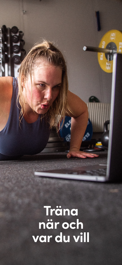 Vibes - 여성이 홈짐 환경에서 노트북으로 온라인 운동을 따라 하면서 푸시업을 하고 있는 모습