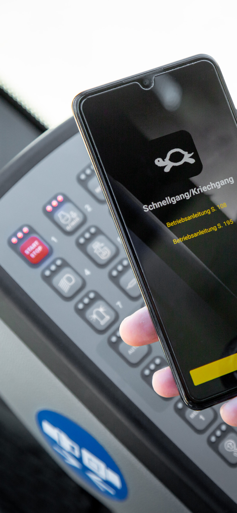 MyAssistant for Earthmoving - Un smartphone usando la app MyAssistant para escanear e identificar un símbolo de tortuga en el panel de control de una máquina Liebherr