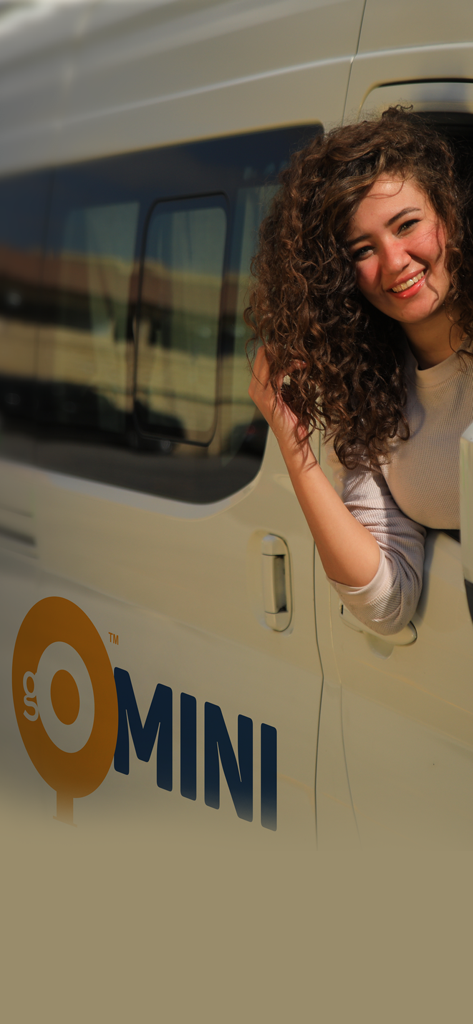 Una mujer sonriente dentro de una camioneta de transporte de lujo GoMini