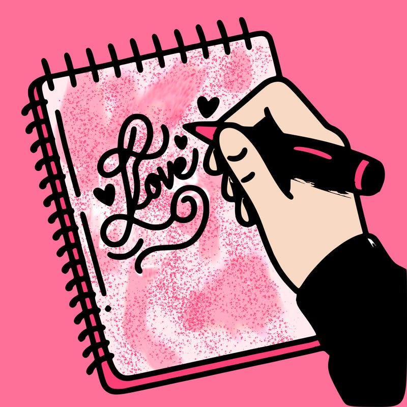 a hand writing “love” in calligraphy on a notebook