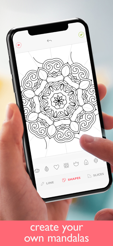 Une main tenant un iPhone utilisant l'application Colorfy pour concevoir un mandala personnalisé