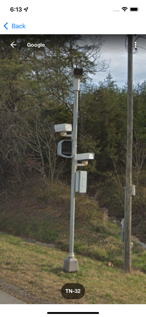 Google Street View image of a roadside pole equipped with speed cameras and traffic sensors