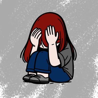 girl sitting down covering her head