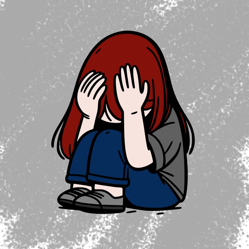 girl sitting down covering her head