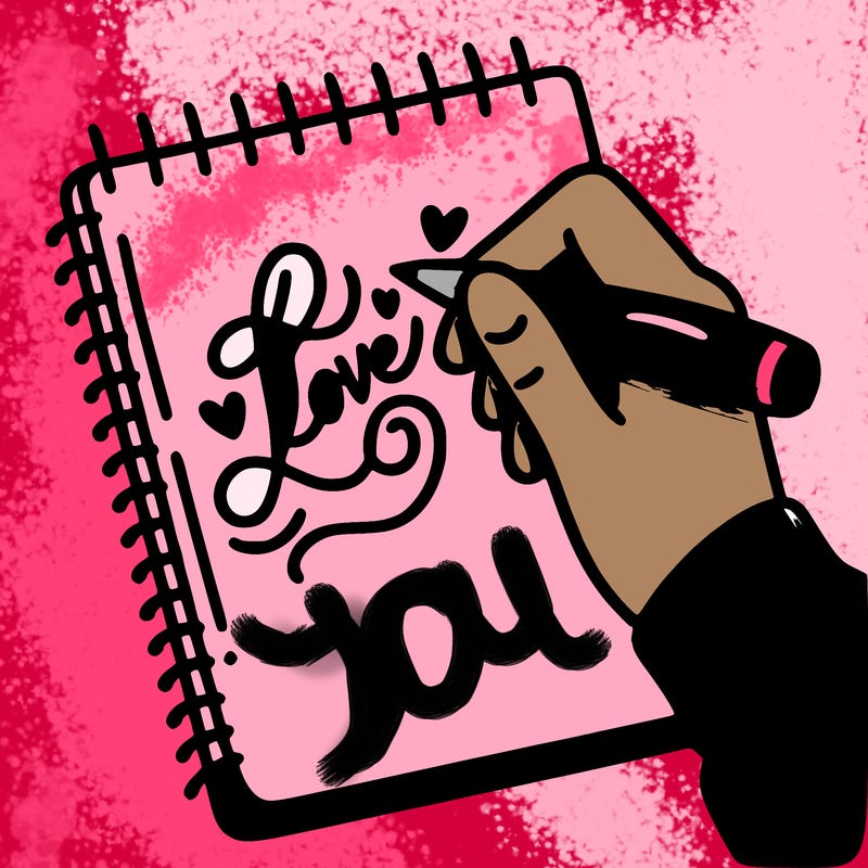 a hand writing “love” in calligraphy on a notebook