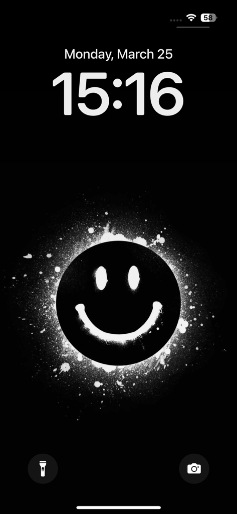 iPhone lock screen with a black background and a white spray-painted smiley face wallpaper.