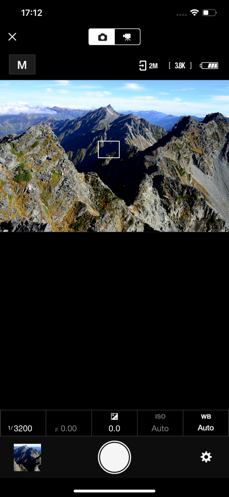 SnapBridge Fernaufnahme-Oberfläche mit einer Live-Vorschau einer Berglandschaft und Kameraeinstellungen.
