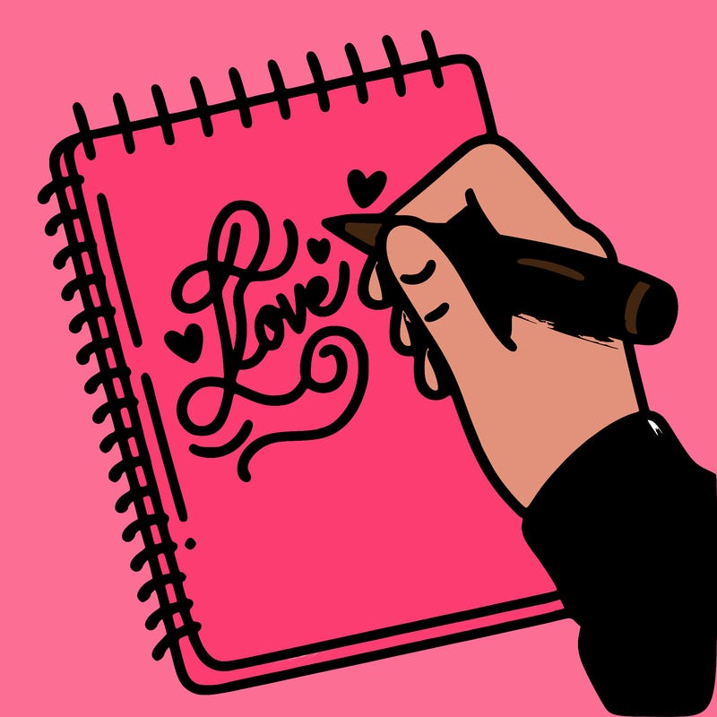 a hand writing “love” in calligraphy on a notebook