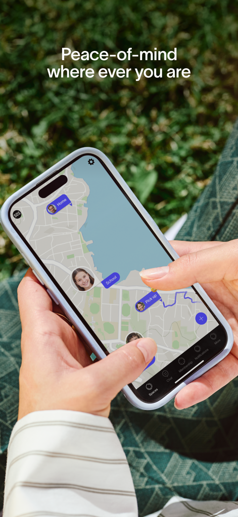 A person holding a smartphone outdoors displaying the Spacetalk app with a real-time GPS map showing family locations at home and school.
