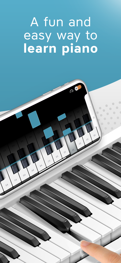 Piano Keyboard App: Play Songs - A smartphone showing a piano learning interface placed on top of a physical white piano keyboard