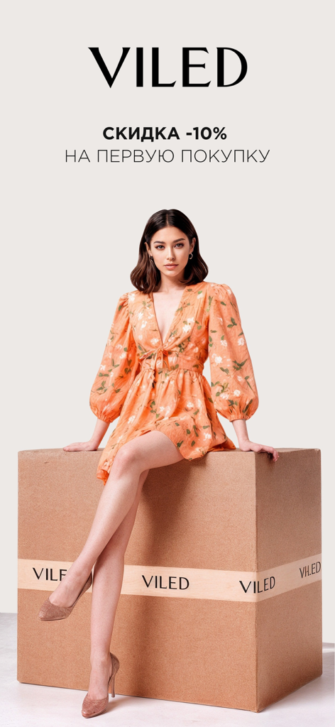 VILED - Una donna con un abito floreale arancione è seduta su una scatola con marchio VILED che pubblicizza uno sconto del 10% sul primo acquisto.