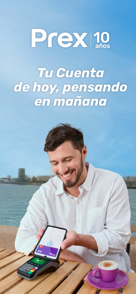 Un homme souriant utilise l'application Prex Uruguay pour effectuer un paiement mobile sans contact à la table d'un café