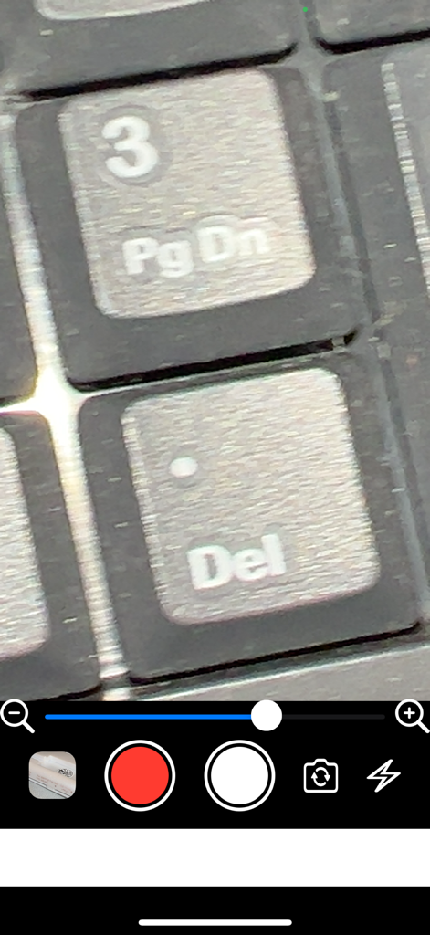 Magnifier Zoom Camera - Interfaz de la aplicación Cámara Zoom Lupa mostrando una vista ampliada de las teclas del teclado con control deslizante de zoom y controles de linterna