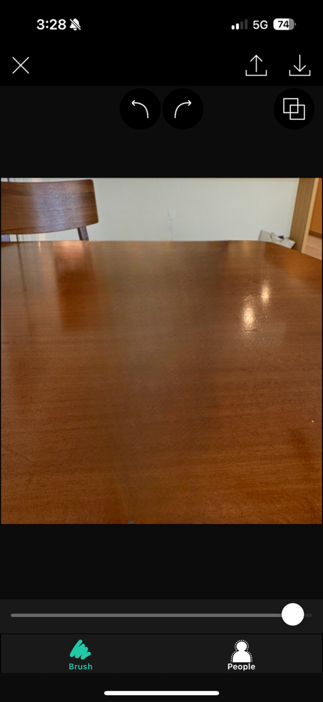 Background Eraser app interface showing a photo of a wooden table with editing tools like brush and people detection