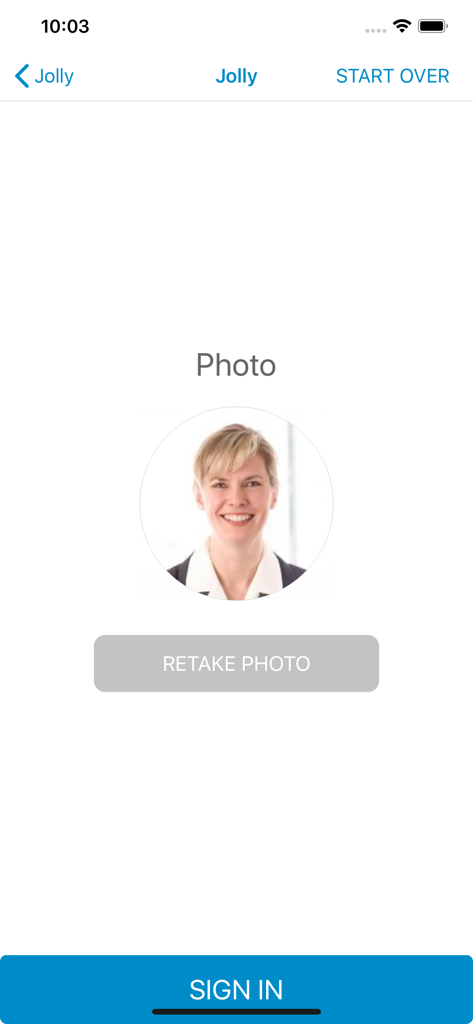 Visitor photo capture and review screen in the Lobbytrack Lobby app showing a retake photo option and a sign in button