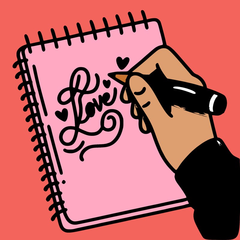 a hand writing “love” in calligraphy on a notebook