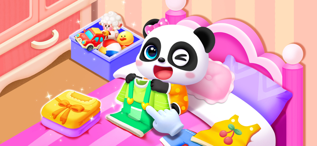 A baby panda being dressed in green overalls on a pink bed in a nursery setting.