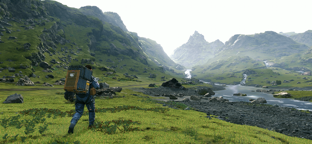 Sam Bridges walking through a green mountain valley with cargo on his back
