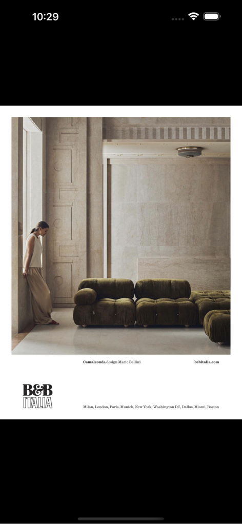 Architectural Digest (Deutsch) - 럭셔리 인테리어에 있는 녹색 퀼팅 B&B Italia Camaleonda 소파 옆 돌 벽에 기대어 있는 여성.