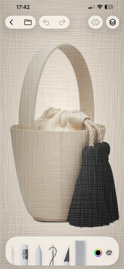 Prêt à Template - Diseño digital de un bolso tipo cubo beige con un borla negra en la aplicación de moda Prêt-à-Template.