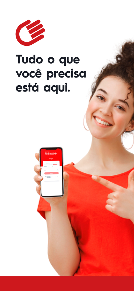 A smiling woman holding a smartphone and pointing to the login screen of the Consorcio Embracon app