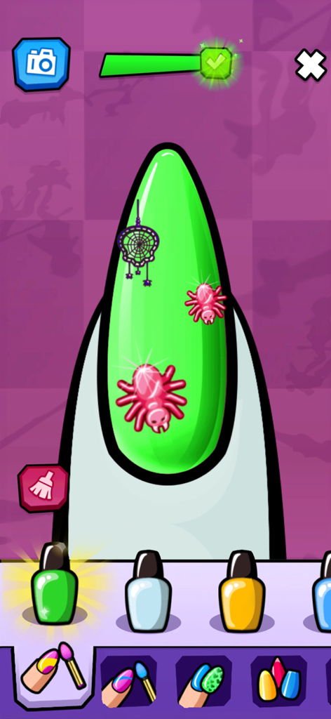 Monster High™ Beauty Salon - Ein grüner spitzer Nagel mit rosa Spinnenaufklebern und einem Netzdesign in einem Maniküre-Spiel