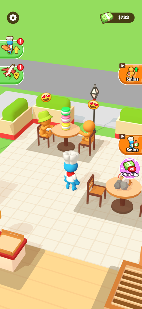 My Sweet Bakery! - A blue chef character standing in a bakery outdoor area with customers sitting at tables and a tall stack of macarons