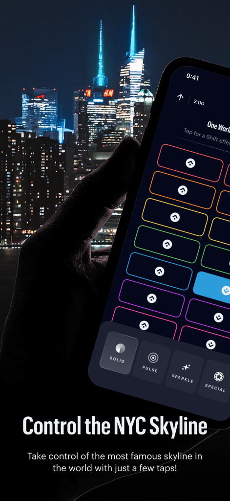 Spireworks - A hand holding a smartphone using the Spireworks app to control the colors of building spires in the New York City skyline at night