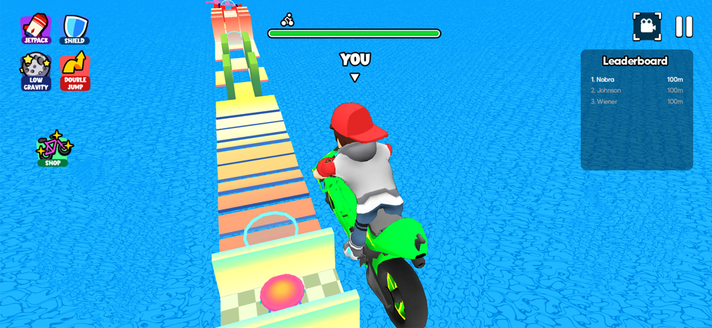 Un personaje montando una motocicleta verde en un estrecho y colorido puente sobre el océano en Minijuegos Desafío Mundial.